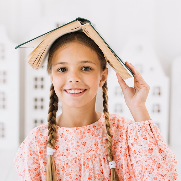 Photo gratuite belle fille heureuse posant avec un livre