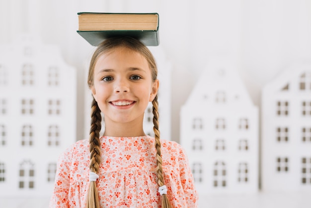 Photo gratuite belle fille heureuse posant avec un livre