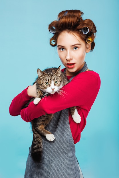 Belle fille avec joli chat dans les mains posant et regardant