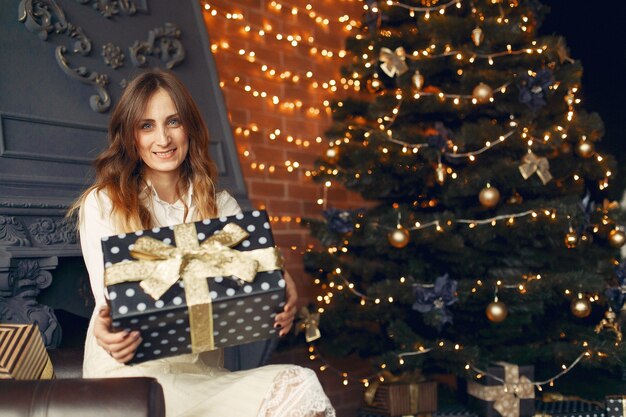 Belle fille à la maison près de l'arbre de Noël