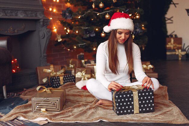 Belle fille à la maison près de l'arbre de Noël