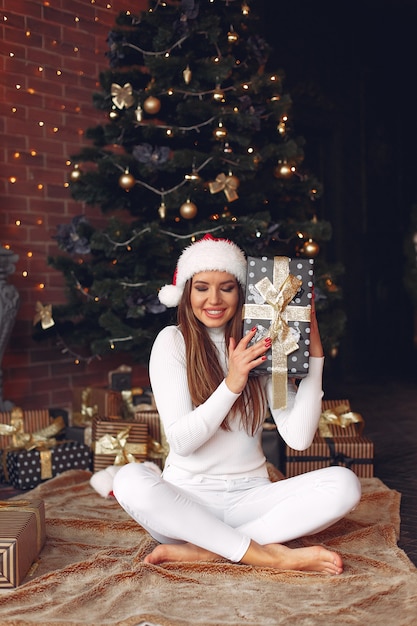 Belle fille à la maison près de l'arbre de Noël