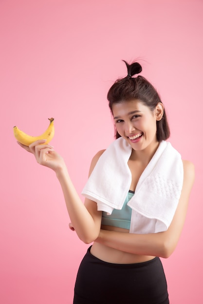 Belle fille mange des bananes après l&#39;effort pour contrôler son poids