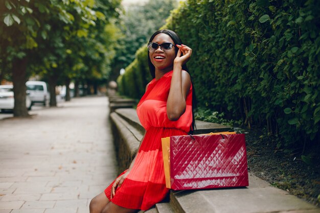 Belle fille noire avec des sacs dans une ville