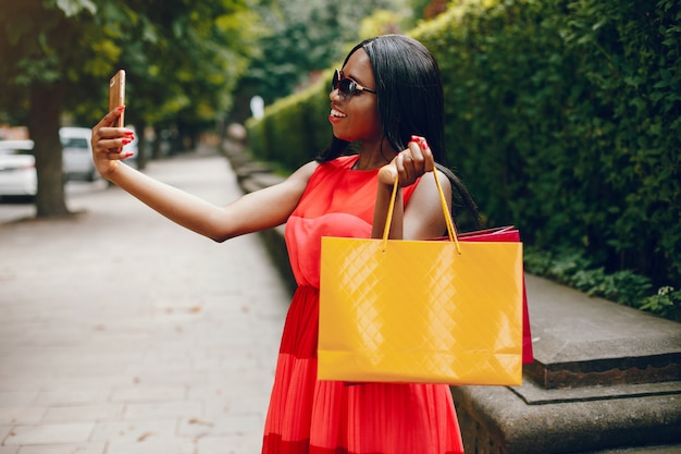 Photo gratuite belle fille noire avec des sacs dans une ville