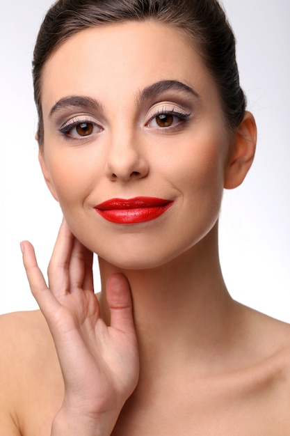 Belle fille avec une peau parfaite et rouge à lèvres