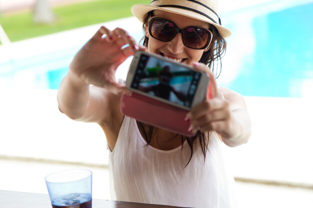 Belle fille prenant un selfie à la piscine.