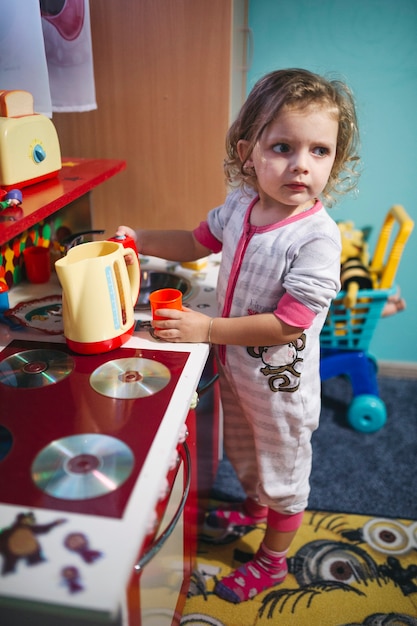 Photo gratuite belle fille près de la cuisine de jouet