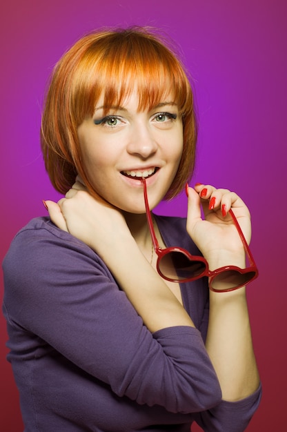 Photo gratuite belle fille rouge avec des lunettes de soleil