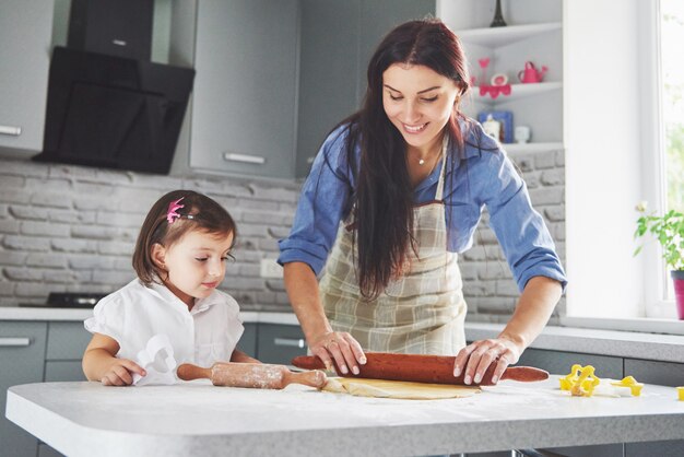 Une belle fille avec sa mère cuisine dans la cuisine