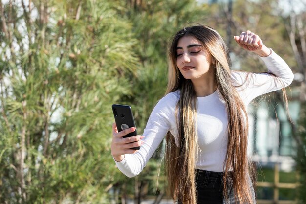 Une belle fille serrant son poing et prenant un selfie Photo de haute qualité
