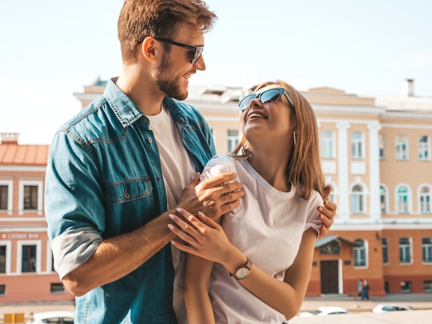 Belle fille souriante et son beau petit ami. Femme en vêtements de jeans d'été décontracté. Se regarder les uns les autres