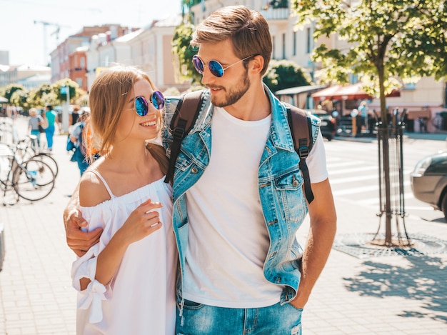 Belle fille souriante et son beau petit ami marchant dans la rue.