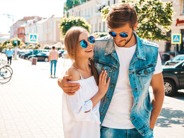 Belle fille souriante et son beau petit ami marchant dans la rue.