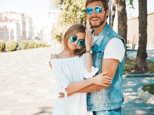 Belle fille souriante et son beau petit ami posant dans la rue.