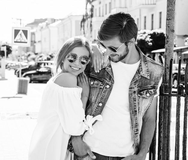 Belle fille souriante et son beau petit ami posant dans la rue.