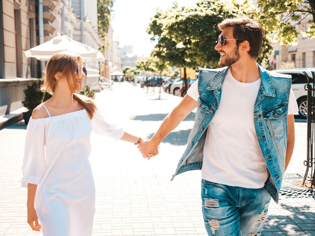 Belle fille souriante et son beau petit ami posant dans la rue.