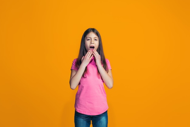 Belle fille à la surprise isolée sur mur orange