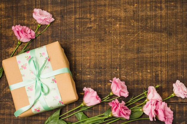 Belle fleur d&#39;eustoma et boîte présente enveloppée décorative sur bois texturé