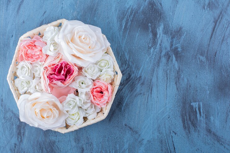 Photo gratuit belle fleur rose colorée dans un panier en osier sur bleu.