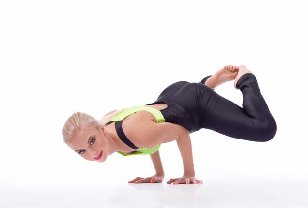 Belle gymnaste féminine faisant un poirier en équilibre gracieusement sur ses bras