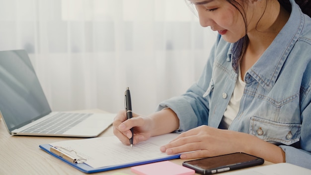 Belle intelligente asiatique jeune entrepreneur femme d&#39;affaires propriétaire d&#39;une PME vérifiant le produit