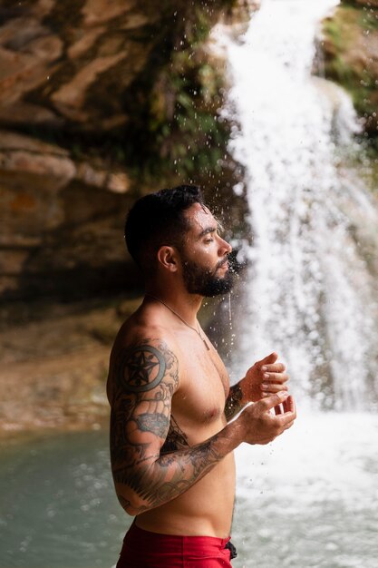 Belle jeune adulte au bord de la cascade