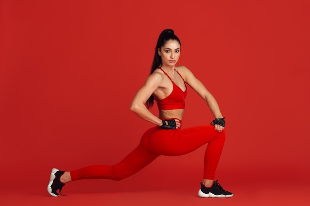 Belle Jeune Athlète Féminine Pratiquant Sur Le Mur Rouge Du Studio