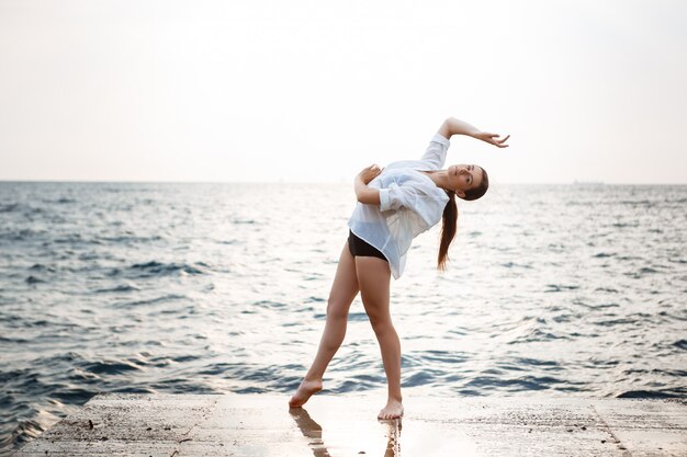 Belle jeune ballerine dansant et posant à l'extérieur