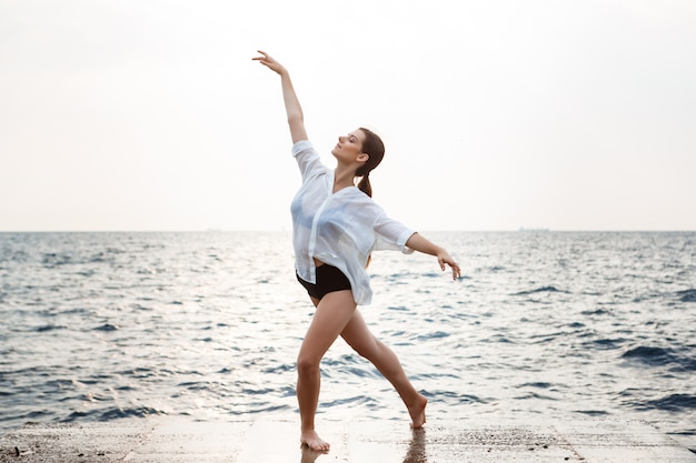 Belle jeune ballerine dansant et posant à l'extérieur