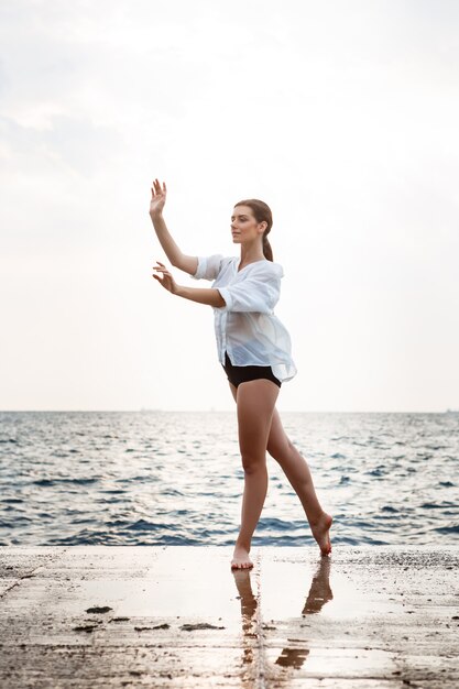 Belle jeune ballerine dansant et posant à l'extérieur