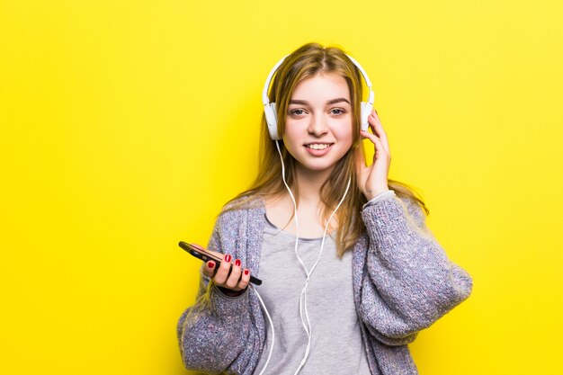 Belle jeune femme appréciant avec l'écoute de la musique dans les écouteurs