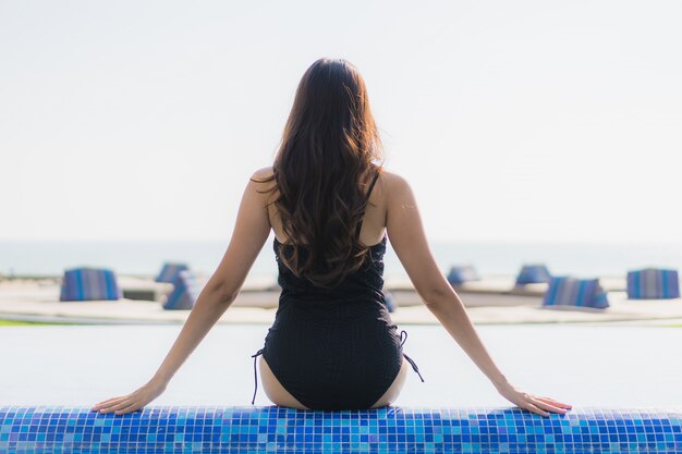 Belle jeune femme asiatique heureuse sourire et se détendre dans la piscine