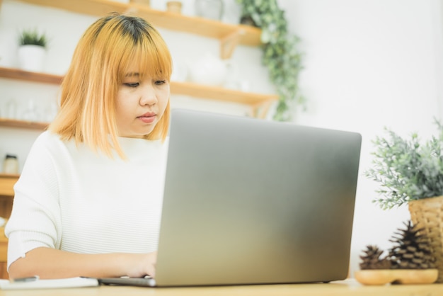 Belle Jeune Femme Asiatique Souriante Travaillant Sur Un Ordinateur Portable à La Maison Dans L'espace De Travail De Bureau