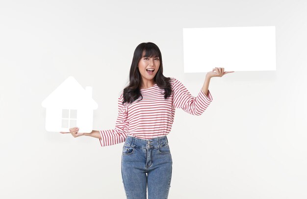 Belle jeune femme asiatique tenant une découpe de maison en papier et une bulle de dialogue sur fond blanc