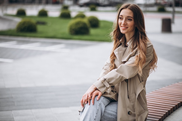 Belle jeune femme assise dans le parc