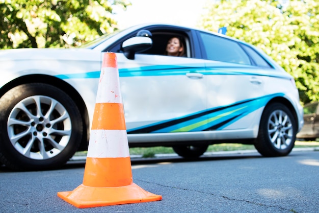 Belle jeune femme assise dans la voiture de l'école prête pour les cours