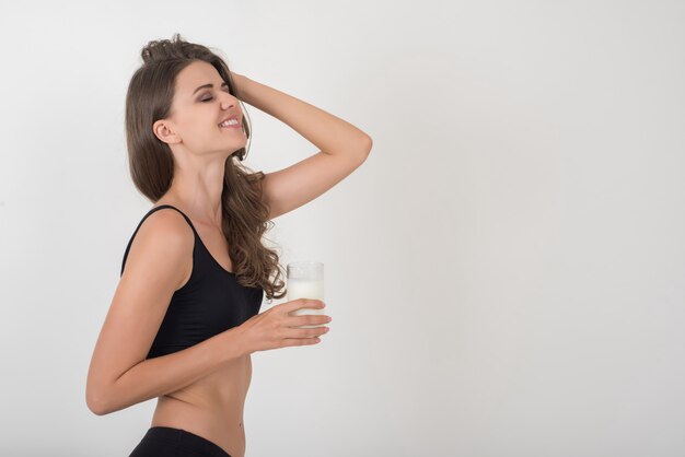 Belle jeune femme au verre de lait