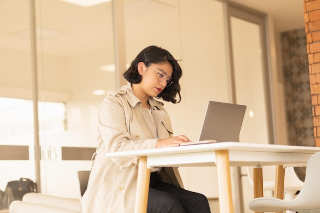 Belle Jeune Femme Aux Cheveux Courts Travaillant Sur L'ordinateur Portable