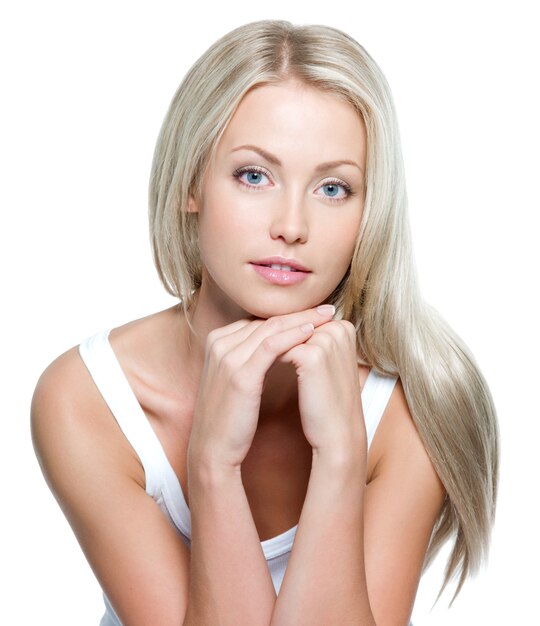 Belle jeune femme aux longs cheveux raides sur un mur blanc