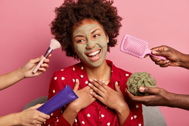 Photo gratuite belle jeune femme bouclée vêtue de vêtements de nuit, sourit sincèrement, regarde de côté