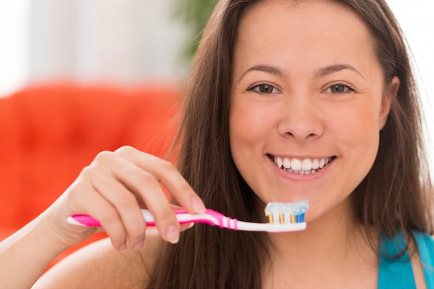 Belle jeune femme avec une brosse à dents