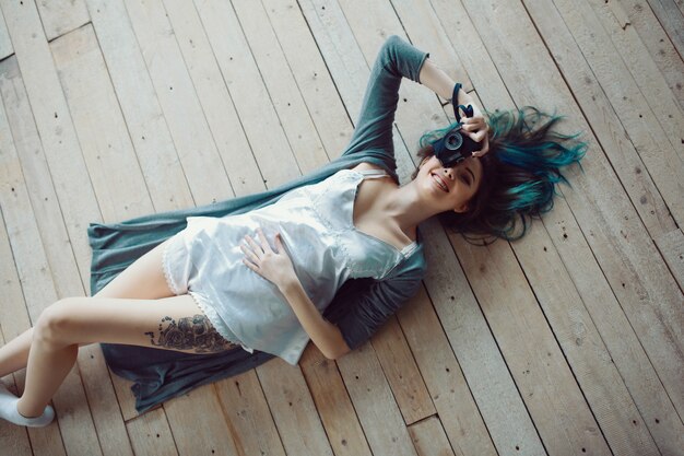 Belle jeune femme casual insouciante allongé sur le plancher en bois