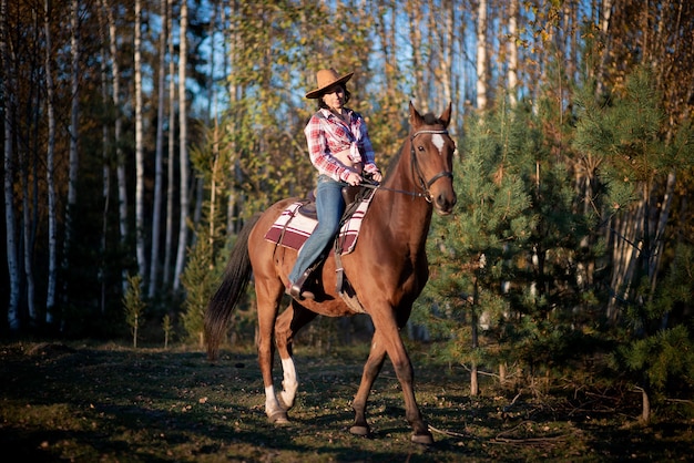 Belle jeune femme et cheval brun pendant l'automne