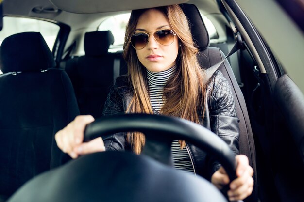 Belle jeune femme conduisant sa voiture.