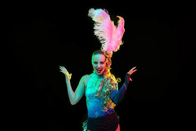 Belle jeune femme en costume de carnaval et de mascarade en néons colorés sur fond noir