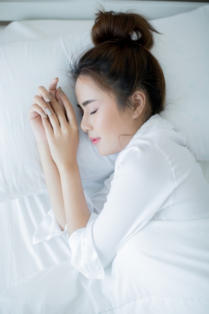 Belle jeune femme couchée dans le lit et dormant.