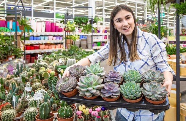 Belle jeune femme dans un magasin de fleurs et choisir des fleurs.