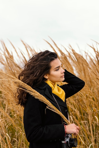 Belle jeune femme dans la nature avec appareil photo