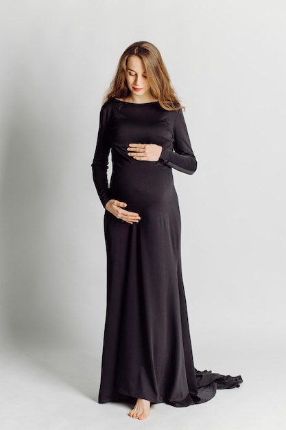 Belle jeune femme enceinte en robe noire Concept de look de mode de grossesse